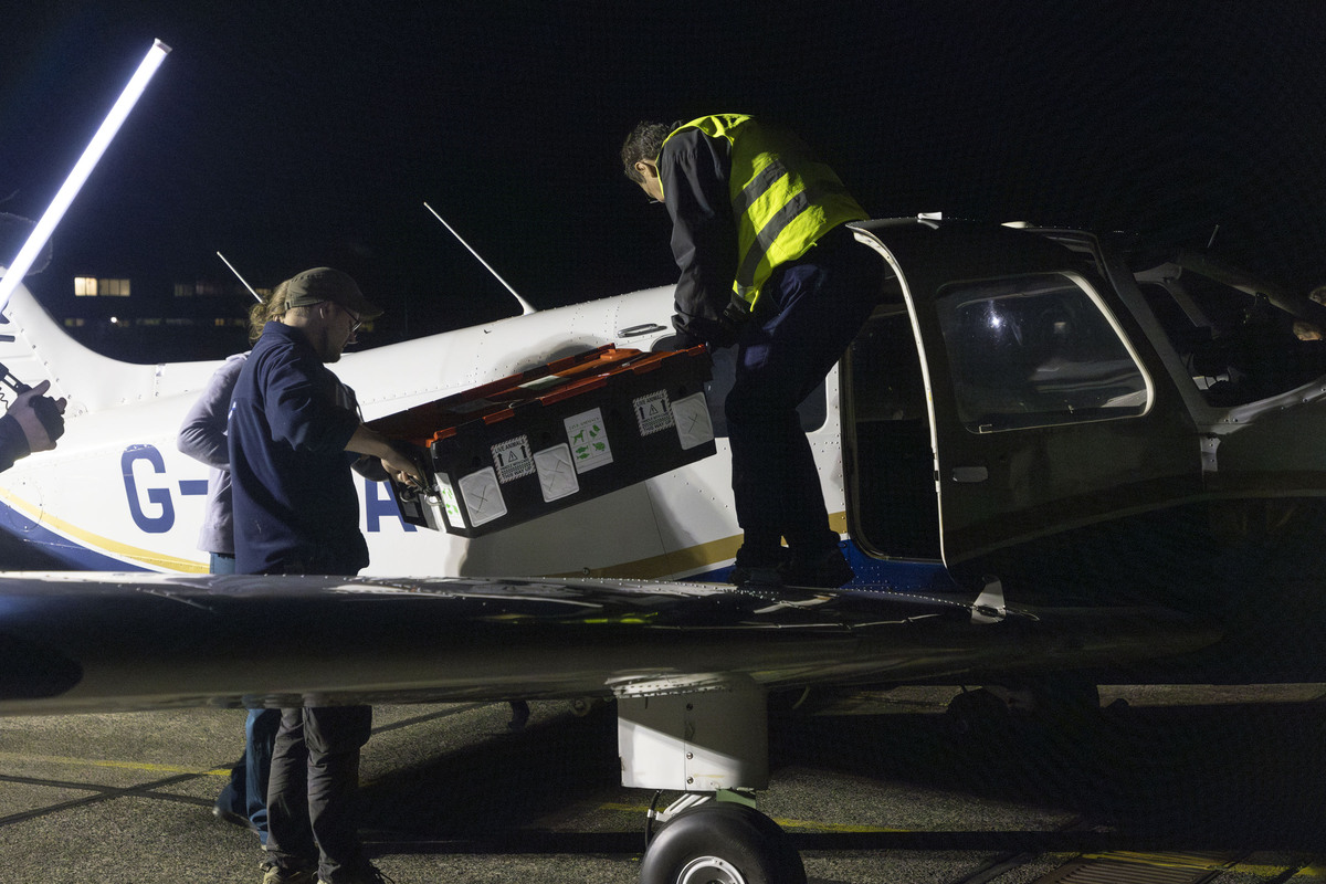 People loading the Turtle container into the light aircraft