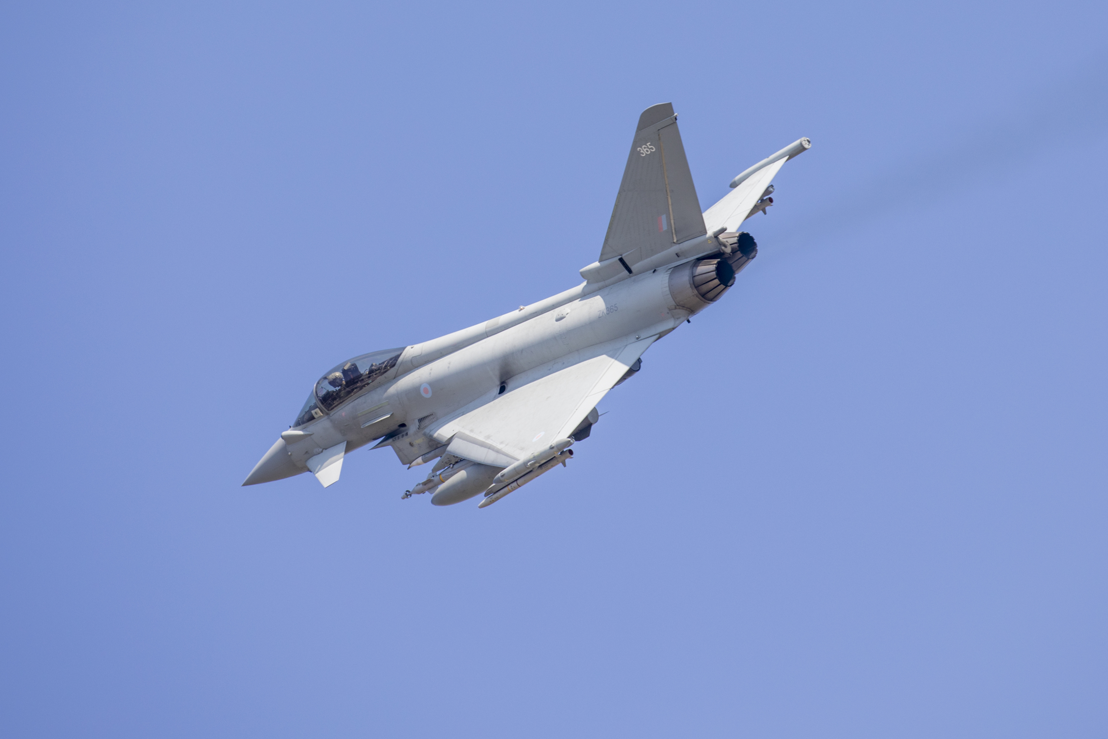 An RAF Eurofighter Typhoon in flight against a blue sky.