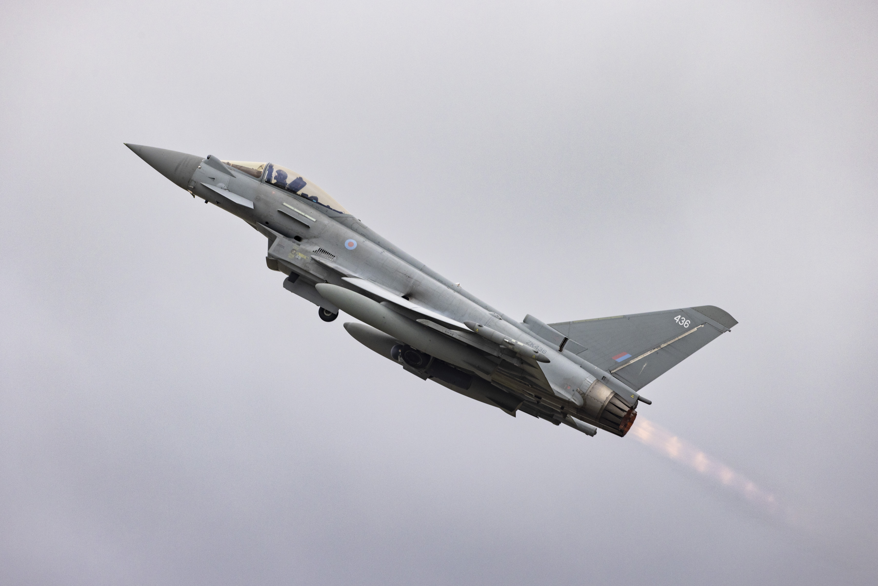 An RAF Eurofighter Typhoon mid-flight against a grey sky.