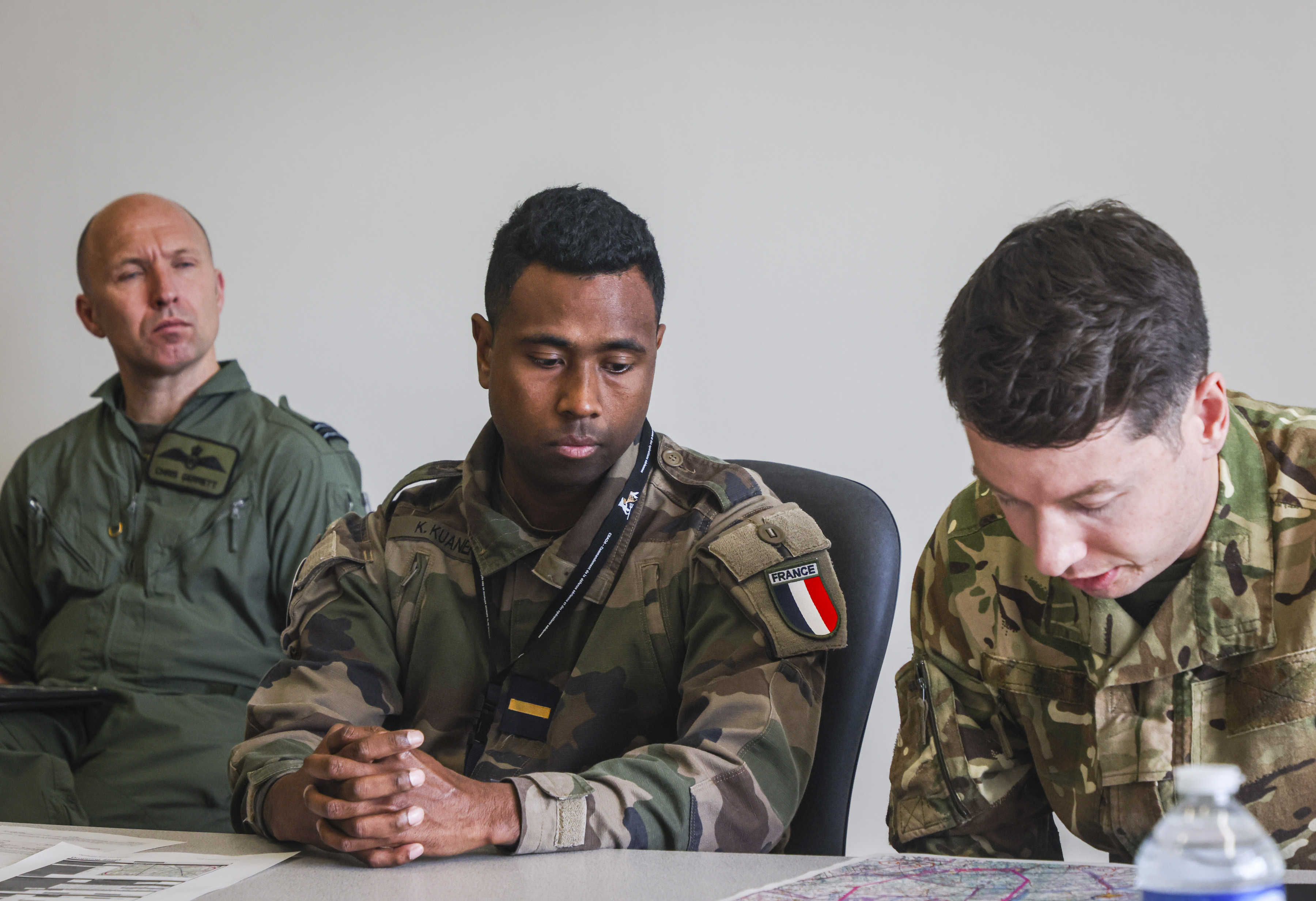 Working with French Air Force personnel, looking at papers on a table