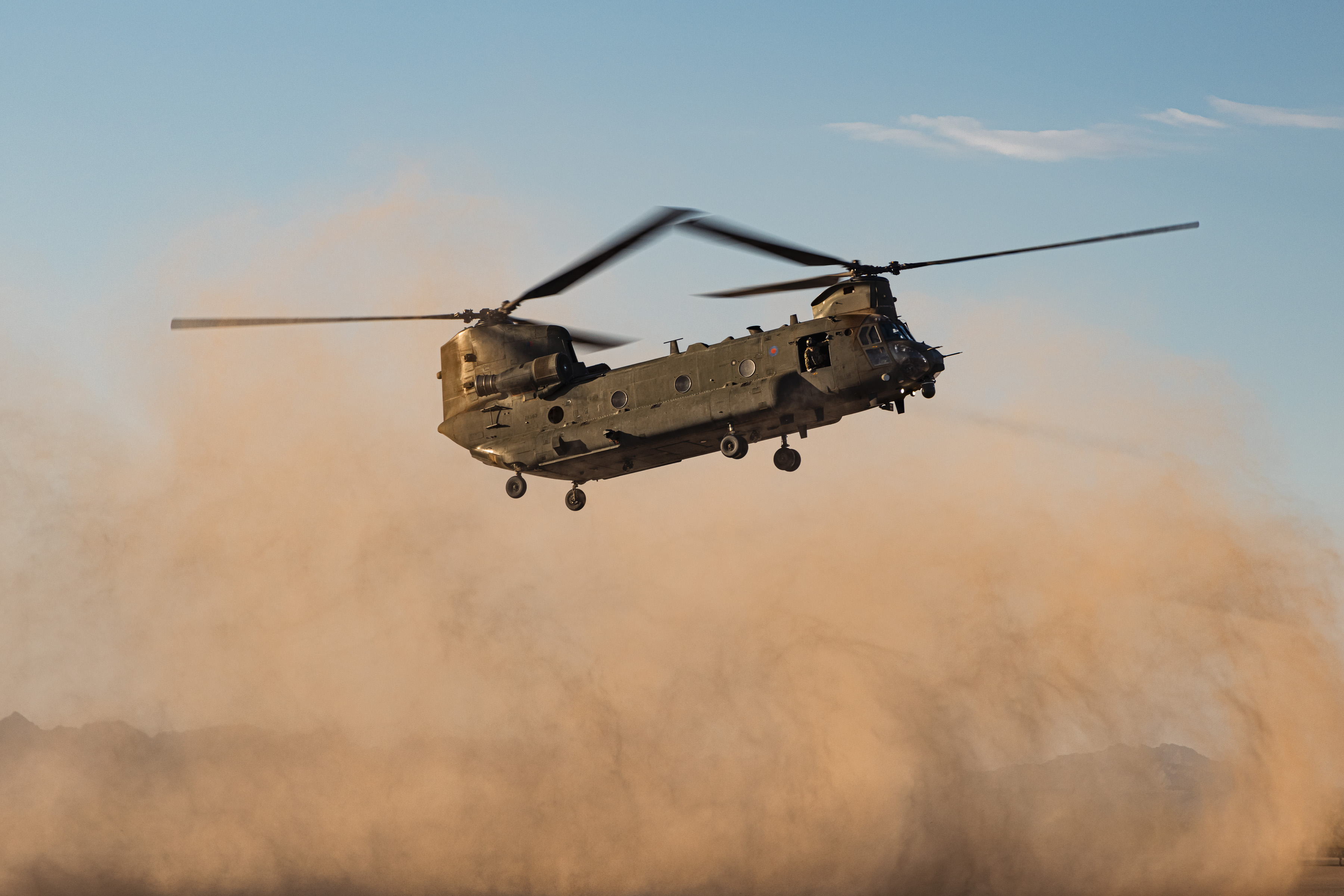 Chinook hovering over desert creating a dust cloud